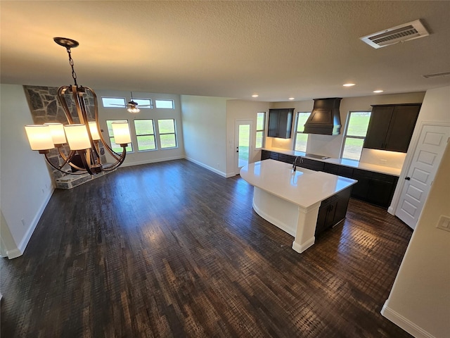 320 Magnolia Ct, Trenton, TX 75490 - kitchen with dark wood finished floors, baseboards, a center island with sink, recessed lighting, and light countertops
