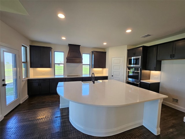 320 Magnolia Ct, Trenton, TX 75490 - kitchen with appliances with stainless steel finishes, custom range hood, dark wood-style flooring, an island with sink, and backsplash