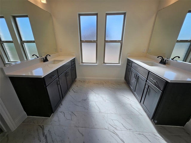 320 Magnolia Ct, Trenton, TX 75490 - bathroom featuring baseboards, marble look tiles, and two vanities