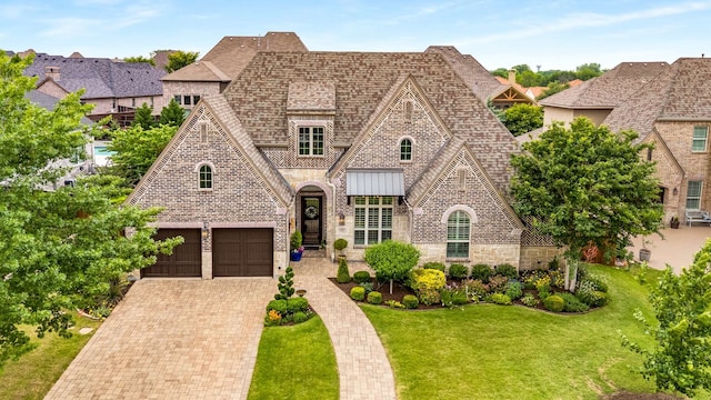 3021 Sunny Hill Ln, Prosper, TX 75078 - view of front of house featuring stone siding, a front yard, a garage, and decorative driveway