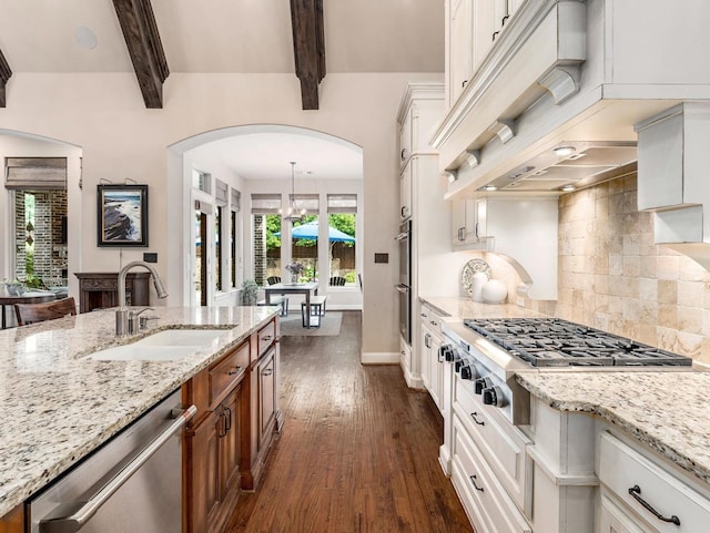 3021 Sunny Hill Ln, Prosper, TX 75078 - kitchen featuring a sink, appliances with stainless steel finishes, arched walkways, premium range hood, and brown cabinets