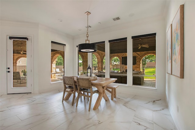 dining space featuring baseboards, crown molding, and light marble finish flooring