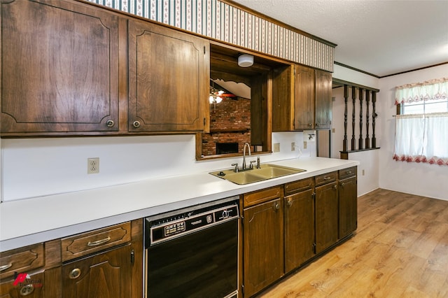 5023 Dedman Dr, Shreveport, LA 71107 - kitchen with black dishwasher, a sink, light wood-style floors, light countertops, and dark brown cabinetry
