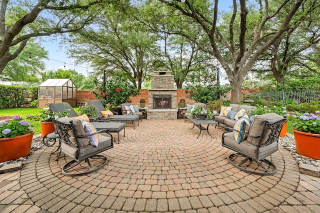4213 Fairway Crossing Dr, Fort Worth, TX 76137 - fenced backyard with a greenhouse, a patio, an outbuilding, and an outdoor living space with a fireplace