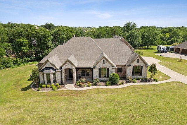 301 Harrison Cir, Van Alstyne, TX 75495 - french country style house with stone siding, roof with shingles, a front lawn, and brick siding