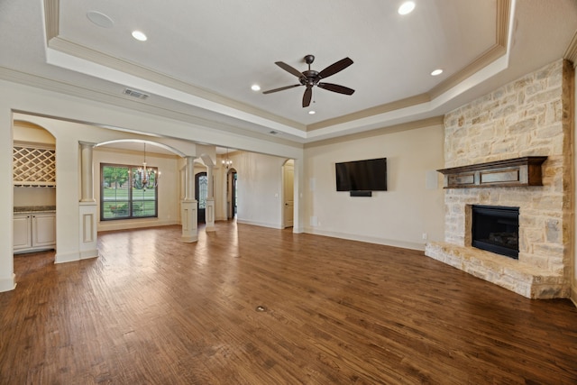 301 Harrison Cir, Van Alstyne, TX 75495 - unfurnished living room featuring a raised ceiling, crown molding, arched walkways, ceiling fan, and a fireplace