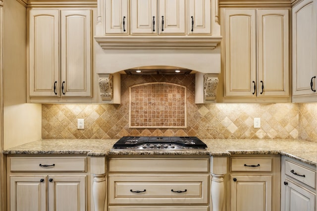 301 Harrison Cir, Van Alstyne, TX 75495 - kitchen with cream cabinets, stainless steel gas cooktop, backsplash, and light stone counters