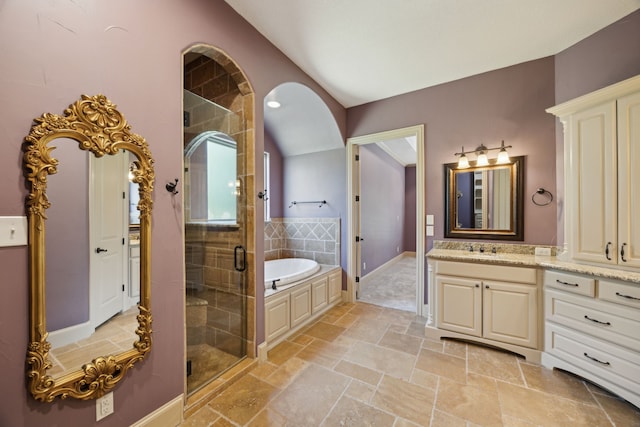 301 Harrison Cir, Van Alstyne, TX 75495 - bathroom with vanity, vaulted ceiling, a garden tub, a stall shower, and stone tile floors