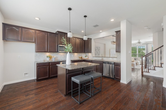 3924 Asbury Ln, Addison, TX 75001 - kitchen featuring appliances with stainless steel finishes, dark brown cabinets, dark wood finished floors, a center island, and a sink