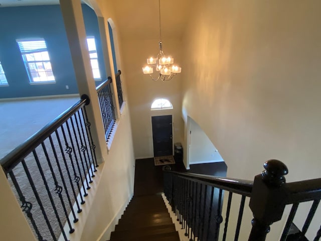 5833 N Silverton Ave, Mckinney, TX 75070 - stairs with a chandelier, arched walkways, and wood finished floors
