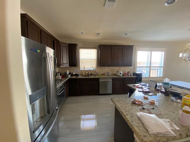 5833 N Silverton Ave, Mckinney, TX 75070 - kitchen with stainless steel appliances, healthy amount of natural light, a sink, dark brown cabinets, and recessed lighting