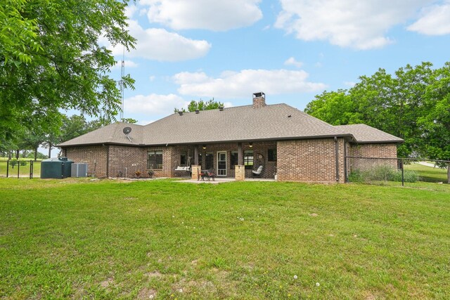 1389 County Road 3591, Paradise, TX 76073 - back of property featuring central AC unit, brick siding, a patio, a chimney, and roof with shingles