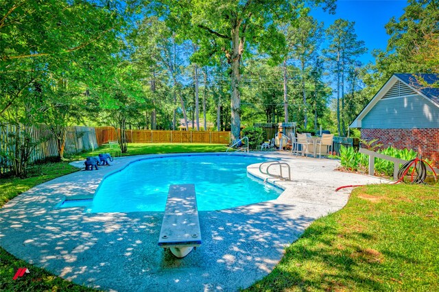 9855 Holamy Ln, Shreveport, LA 71106 - view of pool with a diving board, a patio area, a playground, and view of scattered trees