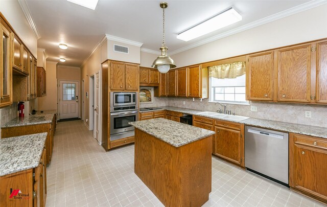 9855 Holamy Ln, Shreveport, LA 71106 - kitchen featuring stainless steel appliances, a sink, crown molding, a center island, and brown cabinets