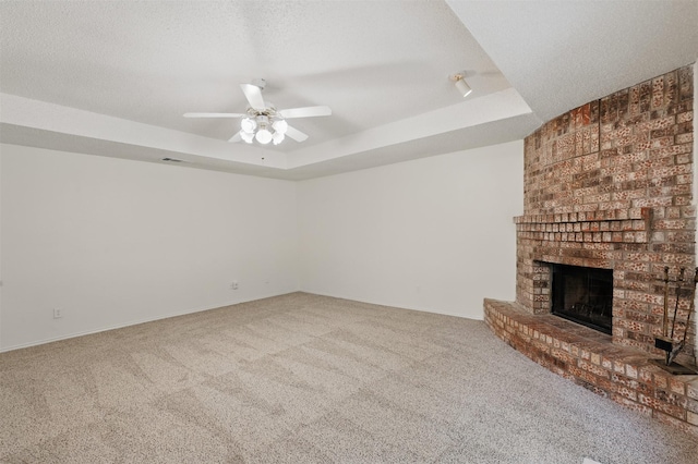 4111 Cypress Springs Dr, Arlington, TX 76001 - unfurnished living room with a tray ceiling, carpet, a brick fireplace, and a textured ceiling
