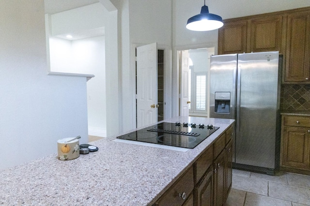 2104 Hunter Place Ln, Arlington, TX 76006 - kitchen featuring stainless steel fridge with ice dispenser, black electric stovetop, backsplash, decorative light fixtures, and brown cabinets