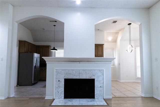 2104 Hunter Place Ln, Arlington, TX 76006 - detailed view of stainless steel fridge with ice dispenser, wood finished floors, a fireplace, and arched walkways