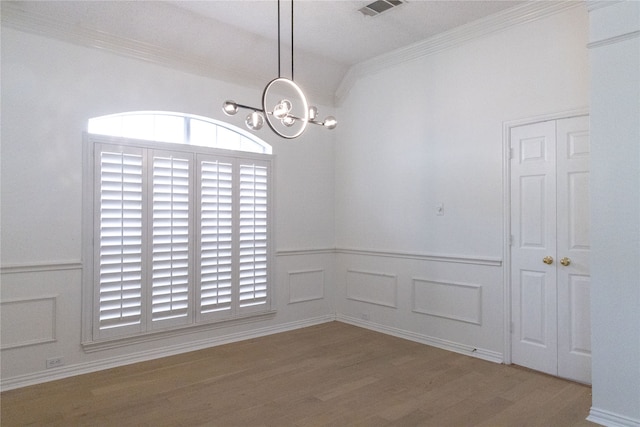 2104 Hunter Place Ln, Arlington, TX 76006 - unfurnished dining area with a chandelier, ornamental molding, wood finished floors, a wainscoted wall, and a decorative wall