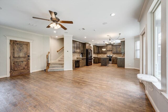 320 Collins St, Argyle, TX 76226 - unfurnished living room with ceiling fan, a chandelier, crown molding, recessed lighting, and stairway
