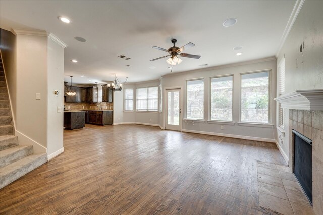 320 Collins St, Argyle, TX 76226 - unfurnished living room with a tiled fireplace, ceiling fan, stairs, ornamental molding, and recessed lighting