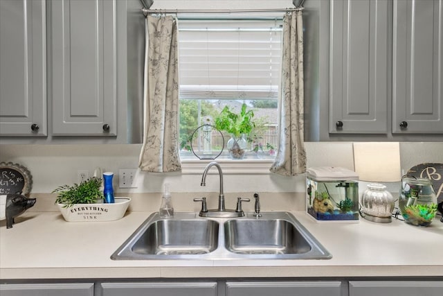 10285 Peony Ln, Waco, TX 76708 - kitchen featuring gray cabinetry, a sink, and light countertops