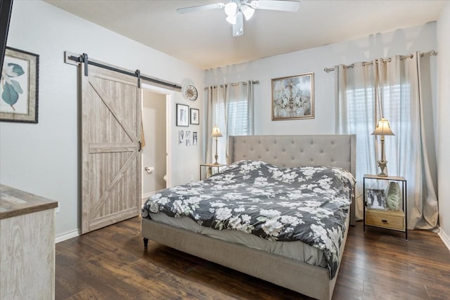 10285 Peony Ln, Waco, TX 76708 - bedroom with a barn door, dark wood-style floors, baseboards, and a ceiling fan