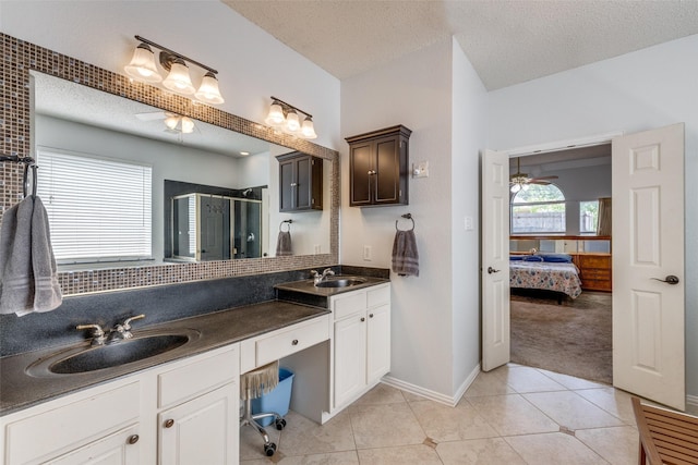1109 Huntington Trl, Mansfield, TX 76063 - bathroom featuring a ceiling fan, a stall shower, a textured ceiling, double vanity, and tile patterned floors