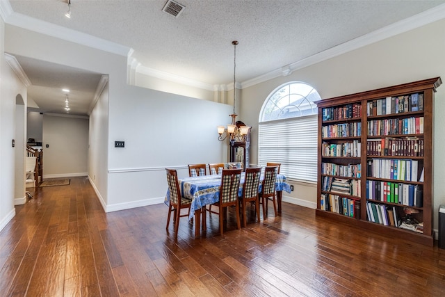 1109 Huntington Trl, Mansfield, TX 76063 - dining area featuring hardwood / wood-style flooring, a chandelier, crown molding, a textured ceiling, and arched walkways