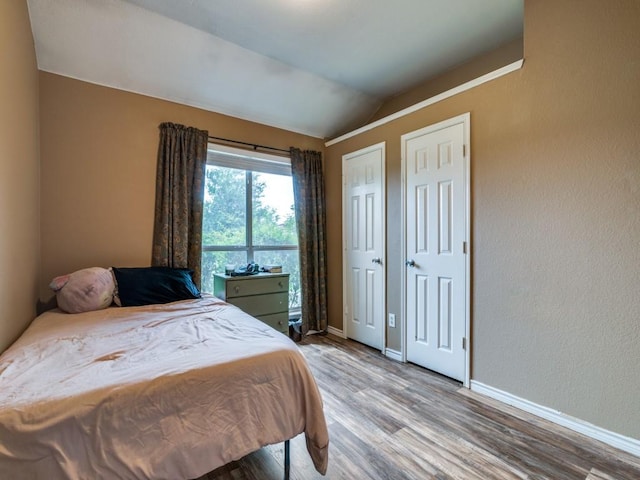 605 Lakeridge Dr, Lavon, TX 75166 - bedroom with wood finished floors, vaulted ceiling, and baseboards