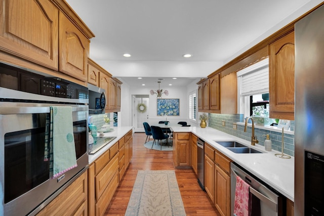 12327 Band Box Pl, Dallas, TX 75244 - kitchen featuring a sink, stainless steel appliances, wood finished floors, backsplash, and recessed lighting