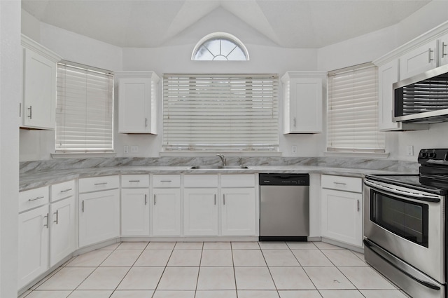 2323 Weatherby Dr, Mesquite, TX 75181 - kitchen with stainless steel appliances, a sink, white cabinets, vaulted ceiling, and light tile patterned flooring