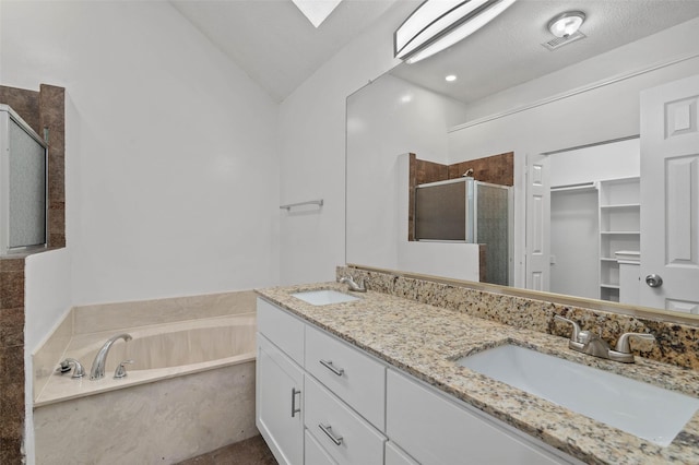 2323 Weatherby Dr, Mesquite, TX 75181 - bathroom with a shower stall, a bath, double vanity, lofted ceiling, and a walk in closet