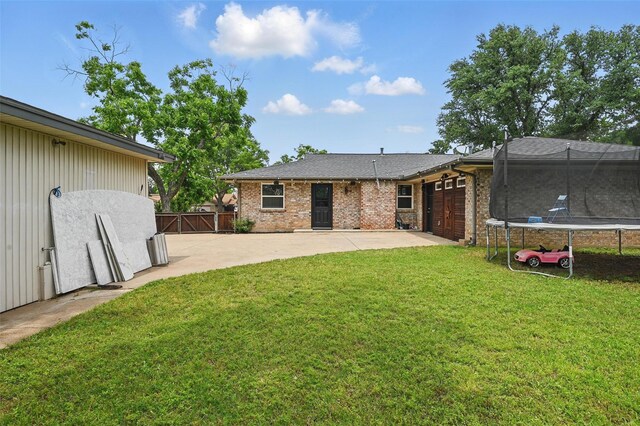1632 Pecan Park Dr, Arlington, TX 76012 - back of house with a trampoline, a patio area, a garage, and brick siding