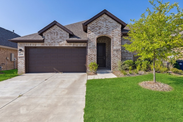 548 Bradley Dr, Fate, TX 75087 - french country home featuring brick siding, a front yard, concrete driveway, a garage, and a shingled roof