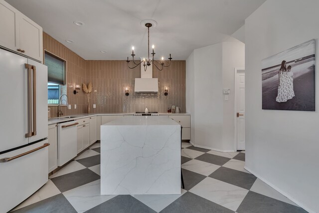 10721 Emerald Park Ln, Fort Worth, TX 76052 - kitchen featuring white appliances, a sink, a kitchen island, a chandelier, and white cabinetry