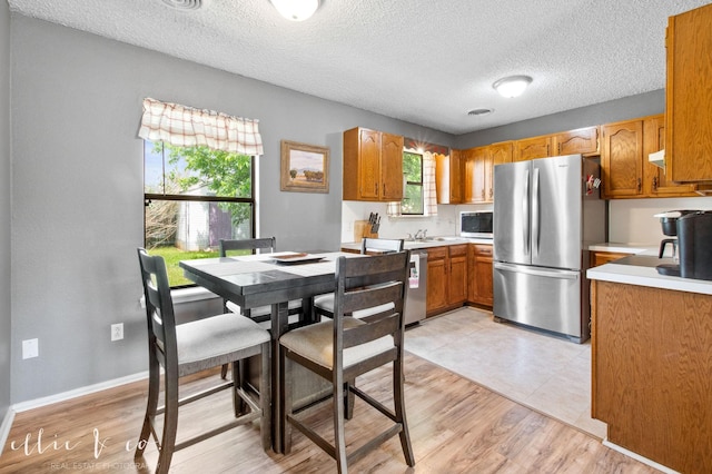 3718 Radcliff Rd, Abilene, TX 79602 - kitchen featuring stainless steel appliances, light countertops, a textured ceiling, and light wood-style flooring