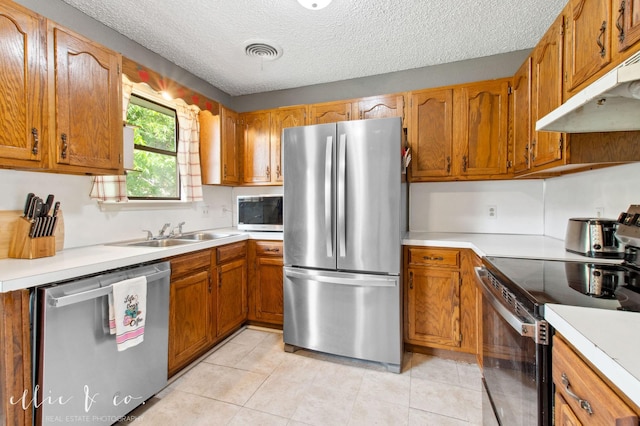 3718 Radcliff Rd, Abilene, TX 79602 - kitchen with stainless steel appliances, under cabinet range hood, a sink, light countertops, and brown cabinets