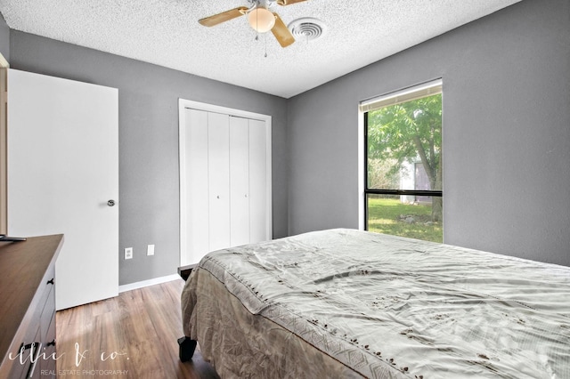3718 Radcliff Rd, Abilene, TX 79602 - bedroom featuring wood finished floors, a closet, a textured ceiling, ceiling fan, and baseboards