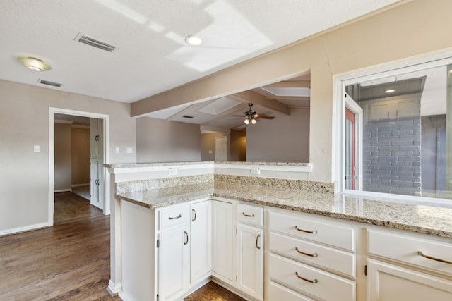 15741 Mapleview Cir, Dallas, TX 75248 - kitchen featuring ceiling fan, light stone counters, dark wood-style floors, white cabinetry, and baseboards