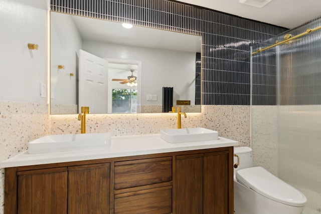 15741 Mapleview Cir, Dallas, TX 75248 - full bathroom featuring toilet, tile walls, double vanity, a shower, and a ceiling fan