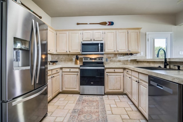 101 Eagle Pt, Graford, TX 76449 - kitchen featuring stainless steel appliances, a sink, light brown cabinets, stone tile floors, and light countertops