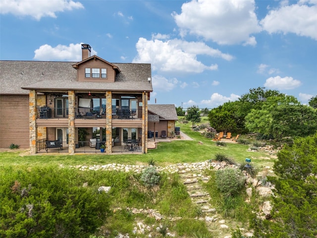 101 Eagle Pt, Graford, TX 76449 - back of house with a patio, a chimney, a balcony, a lawn, and stone siding