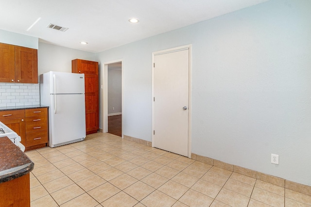 8830 Boundbrook Ave, Dallas, TX 75243 - kitchen featuring white appliances, brown cabinetry, decorative backsplash, recessed lighting, and light tile patterned floors