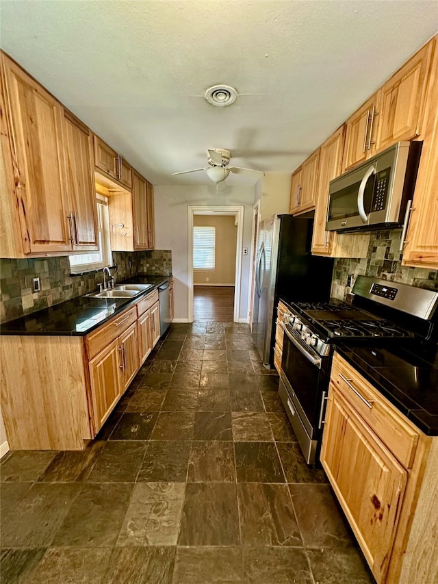 2952 Eric Ln, Farmers Branch, TX 75234 - kitchen featuring appliances with stainless steel finishes, a sink, backsplash, dark countertops, and baseboards