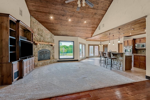 5300 Highland Dr, Denison, TX 75020 - living area with wood ceiling, a ceiling fan, high vaulted ceiling, wood finished floors, and a stone fireplace