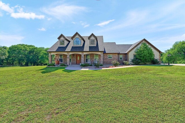 5300 Highland Dr, Denison, TX 75020 - view of front of property featuring a front yard, brick siding, covered porch, and a shingled roof