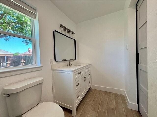 1153 Tracy Ln, Lancaster, TX 75134 - bathroom with toilet, vanity, wood finished floors, and baseboards
