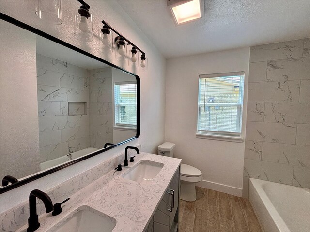 1153 Tracy Ln, Lancaster, TX 75134 - bathroom with toilet, wood finished floors, double vanity, baseboards, and a textured ceiling