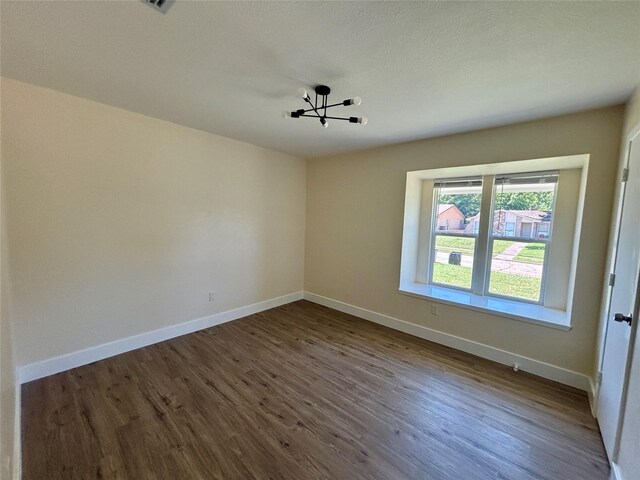 1153 Tracy Ln, Lancaster, TX 75134 - unfurnished room featuring a chandelier, dark wood-style floors, and baseboards