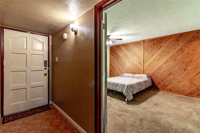 2606 Cedar Elm Ln, Garland, TX 75043 - bedroom with wooden walls, baseboards, a textured ceiling, a textured wall, and a ceiling fan